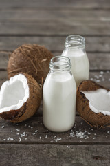 Coconut kefir in bottles on wooden table. Healthy eating concept. Fermented drinks