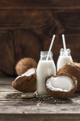 Coconut milk in bottles on wooden table. Healthy eating concept