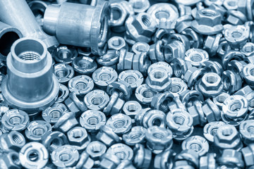 The pile of custom hexagon nut for special purpose in the light blue scene.The industrial corrosion free nut and bolt manufacturing concept.