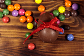 Easter composition with chocolate eggs on wooden background
