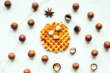 Belgian waffle and macadamia nuts on marble background