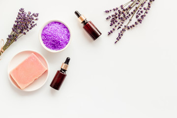 Fototapeta na wymiar Lavender cosmetics. Violet spa salt, soap, essence oil on white background top-down copy space