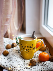 Photo of a yellow cup with delicious tea, table setting for Christmas, tea mug on a brown glowing background, holiday star decoration, Christmas decoration, Christmas home decor