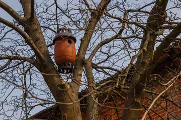 Ceramic birdhouse mounted on a tree.