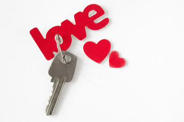 the word love has red lettering on paper background, heart and keys