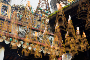 Burning spiral incense sticks hanging from the ceiling of Chua Ba Thien Hau pagoda in Ho Chi Minh,...