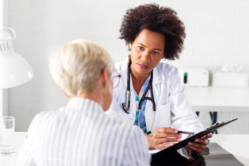 Mature woman with her doctor in ambulance talking about healthcare - Powered by Adobe