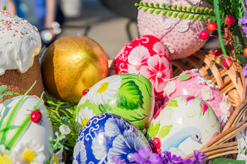 Easter street vestival in Moscow, Russia. Wicker basket full of painted easter eeggs, cake and flowers.