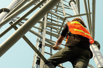 engineer wear safety equipment and climb high telecom tower work for maintenance working.