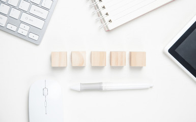 Wooden blank cubes, keyboard, tablet, notepad, mouse.