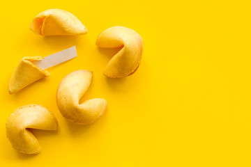 Traditional fortune cookies on yellow table top-down copy space