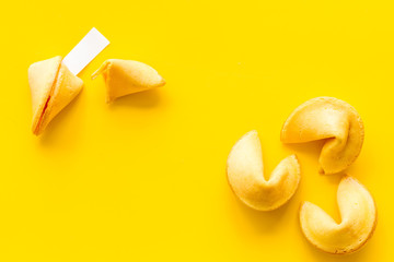Traditional fortune cookies on yellow table top-down copy space