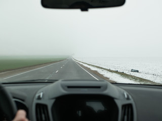 The car goes into the fog. front view. unsafe riding. The car goes fast on the road in the fog, view from the passenger compartment.