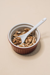 Pile of shelled walnuts in glass bowl, healthy eating concept 