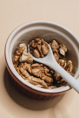 Pile of shelled walnuts in glass bowl, healthy eating concept 