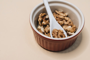 Pile of shelled walnuts in glass bowl, healthy eating concept 