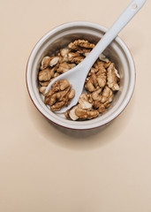Pile of shelled walnuts in glass bowl, healthy eating concept 