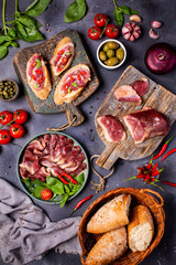 Smoked roasted goose carpaccio on wooden table with garnish green salad