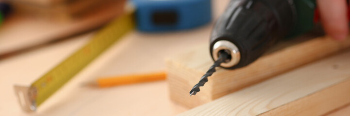 Arms of worker using electric drill closeup. Manual job DIY inspiration improvement job fix shop yellow helmet joinery startup idea industrial education profession career concept