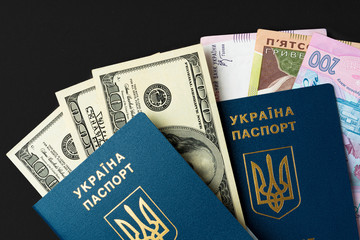 Ukrainian citizen passport with US dollars and Ukrainian hryvnia banknotes inside. Going abroad, exchange rate concept
