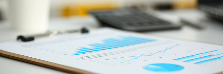 Financial statistics documents on clipboard pad at office table closeup. Internal Revenue Service...