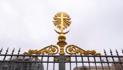 Fototapeta na wymiar Golden russian cross on the door front of The Cathedral of the Lord's Transfiguration of all the Guards in Saint Petersburg, Russia