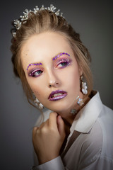 Portrait of a beautiful girl. Face of model with purple make-up. Beauty.Winter make-up.
