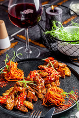 Indian kitchen. Fried chicken slices with curry sauce, hot red pepper and vegetables. Modern serving dishes in the restaurant. background image, copy space text