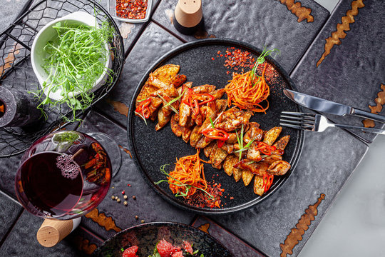 Indian kitchen. Fried chicken slices with curry sauce, hot red pepper and vegetables. Modern serving dishes in the restaurant. background image, copy space text