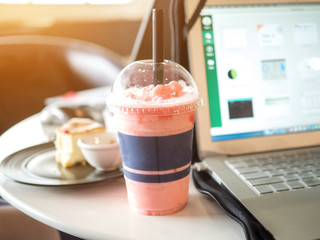 Businesswomen drinking strawberry smoothie fresh and cake sweet dessert  health food  lifestyle between work freelance.Laptop Notebook computer technology digital is on table wood sofa black color 