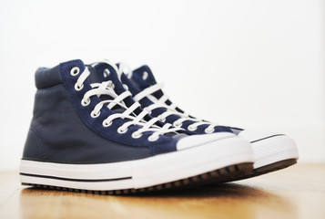 Blue leather sneakers on the floor.