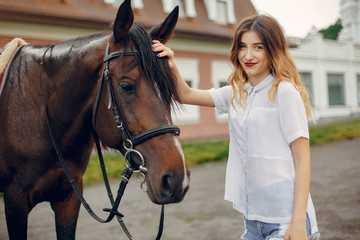 Fototapeta premium Woman standing with a horse. Lady in a white shirt