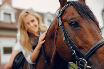 Fototapeta premium Woman standing with a horse. Lady in a white dress