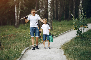 Family on a yard. Father with son with green funnel and shovel