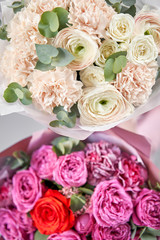 Two Beautiful bouquets of mixed flowers in womans hands. the work of the florist at a flower shop. Delivery fresh cut flower. European floral shop.