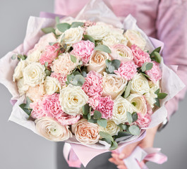 European floral shop. Beautiful bouquet of mixed flowers in womans hands. the work of the florist at a flower shop. Delivery fresh cut flower.