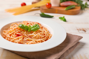 Plate with tasty pasta and tomato sauce on table, closeup