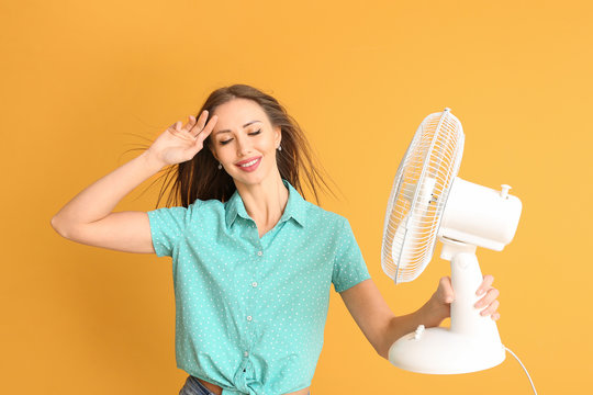 Young Woman With Electric Fan On Color Background