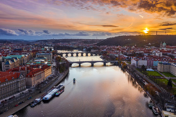 Fototapeta premium Prague, Czech Republic - Aerial panoramic drone view of the city Prague with the world famous Charles Bridge (Karluv most), Mánes Bridge and St. Francis Of Assisi Church and a magical winter sunset