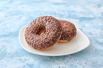 Plate with sweet tasty donuts on table