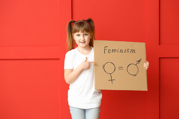 Little girl holding cardboard with symbols of man and woman on color background. Concept of feminism