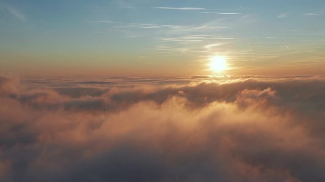 Flying above the clouds with a beautiful golden clouds and sunset and blue sky