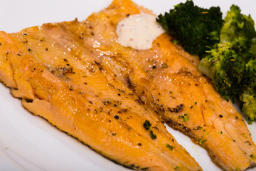 Dish of  tasty  steak of  fried rainbow trout fillet with broccoli