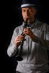 clarinet in the hands of a man on a black background