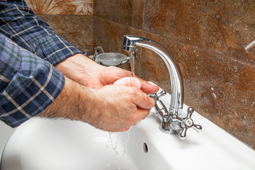 The man washes his hands in the sink. The concept of care for cleanliness, personal hygiene....