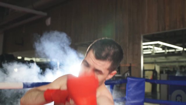 Boxer conducts sparring in the ring. Male boxer sends his opponent to knockout