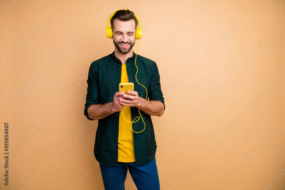 Sticker photo of attractive funny guy holding telephone hands listening youth songs cool modern yellow earph