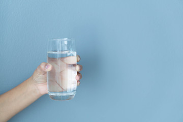 Close up woman hand holding glass of pure water with smile face background, Selective focus