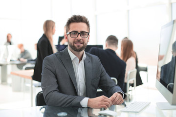 successful young businessman sitting at an office Desk.