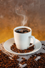 White coffee cup and coffee beans on wooden background